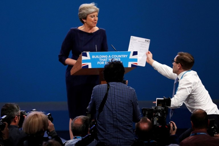 A member of the audience hands a P45 form (termination of employment tax form) to Britain''s Prime Minister Theresa May as she addresses the Conservative Party conference in Manchester