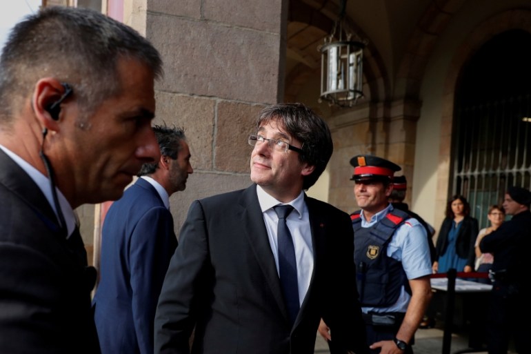 Catalan President Carles Puigdemont looks back as he enters the Catalonian regional parliament in Barcelona