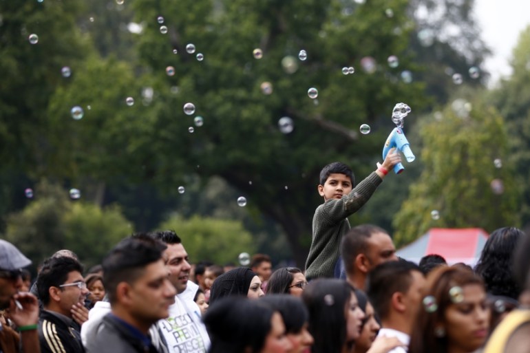 A boy sprays bubbles as people listen to music during Eid Mela in Birmingham