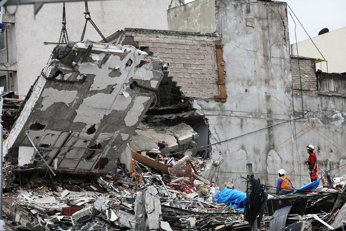 Members of a rescue team work to remove the last body trapped under the rubble of a collapsed building at Alvaro Obregon Avenue in the Condesa neighborhood. REUTERS/Nacho Doce