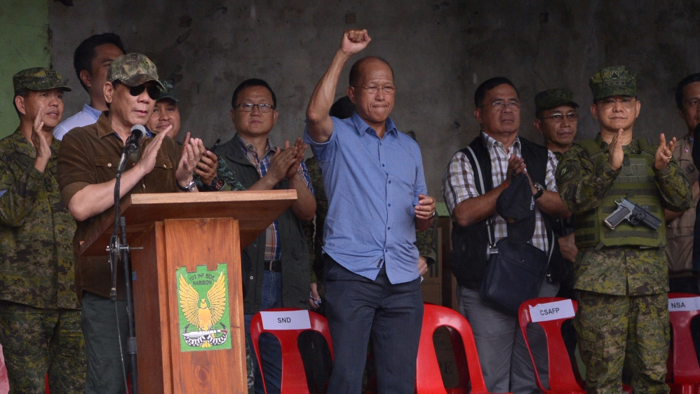 President Duterte and his defence chief Delfin Lorenzana (with raised arm) rallied troops in Marawi on Tuesday [AFP]