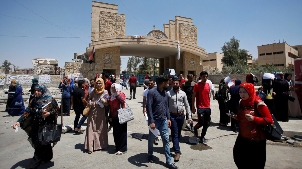 University of Mosul students walk outside the campus in Mosul in July [Khalid al-Mousily/Reuters]