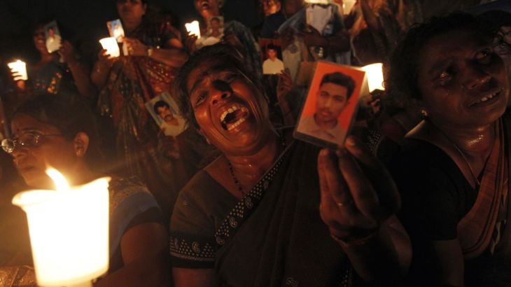A Tamil woman cries as she holds up an image of her family member who disappeared during the civil war with the LTTE at a vigil to commemorate the international day of the disappeared in Colombo