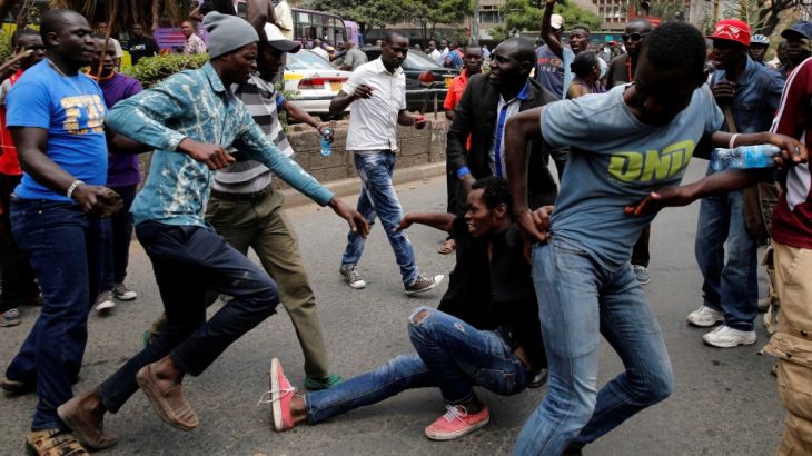 Supporters of Kenyan opposition National Super Alliance coalition accost a man suspected of stealing during a demonstration in Nairobi