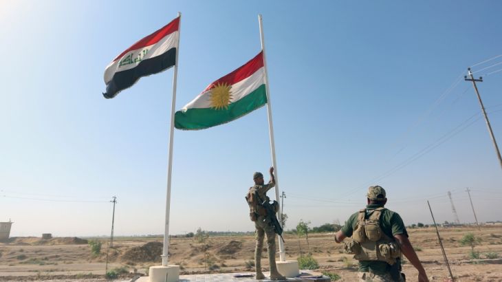 Member of Iraqi security forces takes down the Kurdish flag in Kirkuk