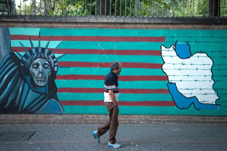 Man walks past anti-U.S. mural in Tehran