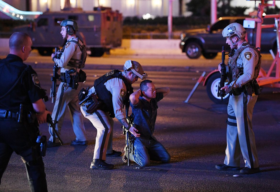 Police officers stop a man who drove down Tropicana Ave. near Las Vegas Boulevard and Tropicana Ave, which had been closed after a mass shooting at a country music festival that left at least 2 people