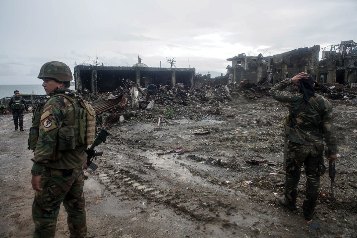 epa06271156 Filipino soldiers conduct patrol next to bombed-out buildings in the ruined city of Marawi, southern Philippines, 17 October 2017. The President of the Philippines declared the city of Mar