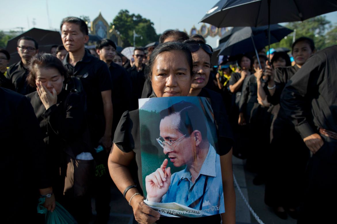 Thai mourners stand in a line to pay respect to a portrait of late Thai King Bhumibol Adulyadej in a replica of the royal crematorium in Bangkok, Thailand, Thursday, Oct. 26, 2017. Tearful Thais clad