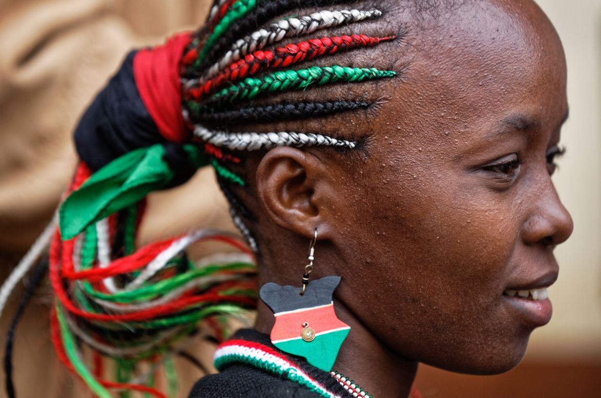 Esther Wanjiru Njoroge wears braids and earrings in the colors of the Kenyan flag, as she waits to cast her vote in President Uhuru Kenyatta''s hometown of Gatundu, Kenya Thursday, Oct. 26, 2017. Kenya