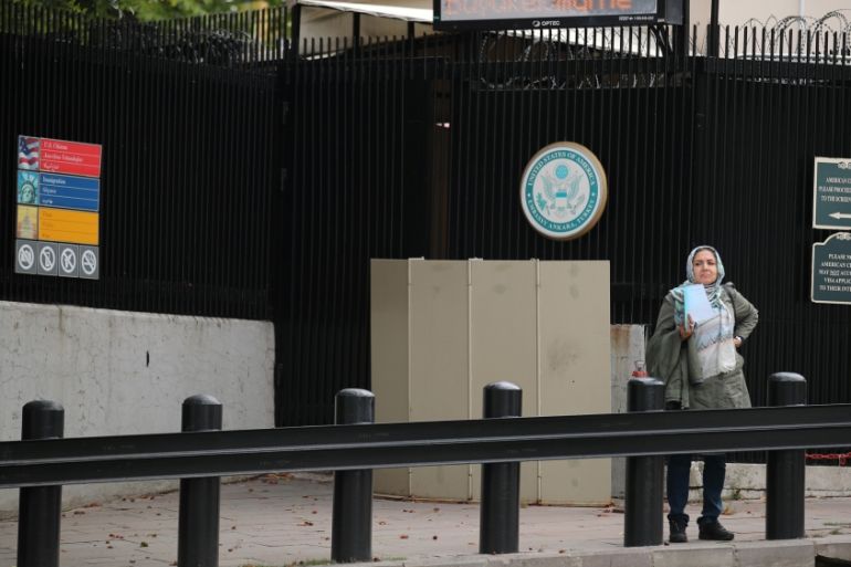 A woman waits in front of the visa application office entrance of the U.S. Embassy in Ankara