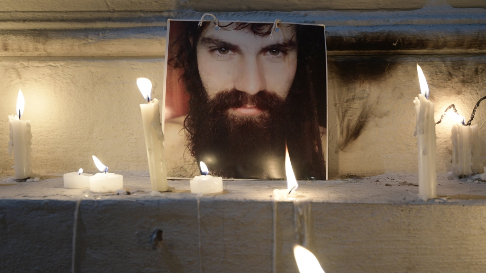 A portrait of Santiago Maldonado is surrounded by candles outside the judicial morgue where his autopsy was carried out in Buenos Aires [Juan Mabromata/AFP/Getty Images]