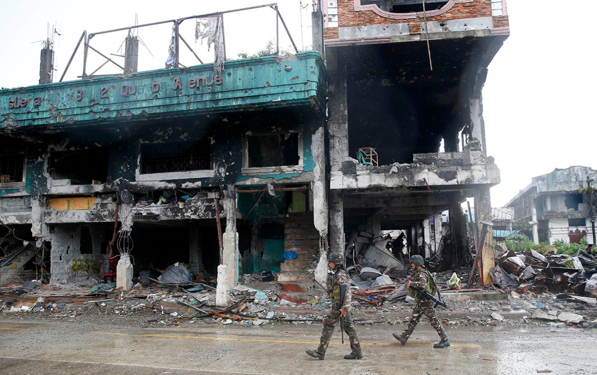 A soldier patrols the decimated streets of Marawi city, southern Philippines, after President Rodrigo Duterte declared its liberation almost five months since the siege by pro-Islamic State group mili