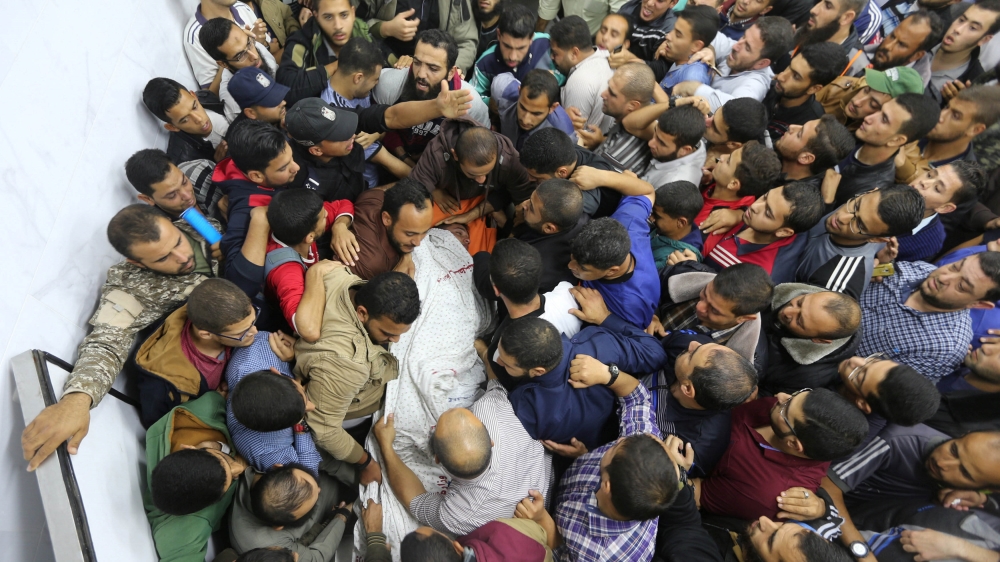 People carry the body of a Palestinian who was killed near the border between Israel and central Gaza Strip [Ibraheem Abu Mustafa/Reuters]