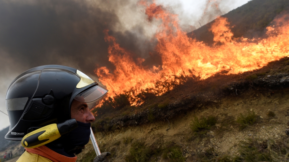 A firefighter tries to put out a fire in Tablado, Asturias, in northern Spain [Eloy Alonso/Reuters]