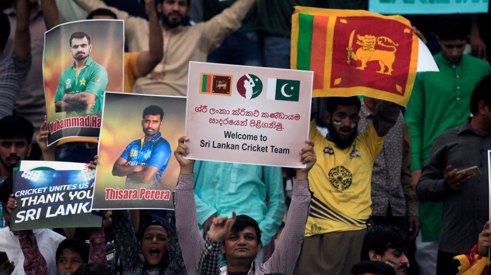 Spectators hold placards during the T20 international cricket match between Pakistan and Sri Lanka [Mohsin Raza/Reuters] 