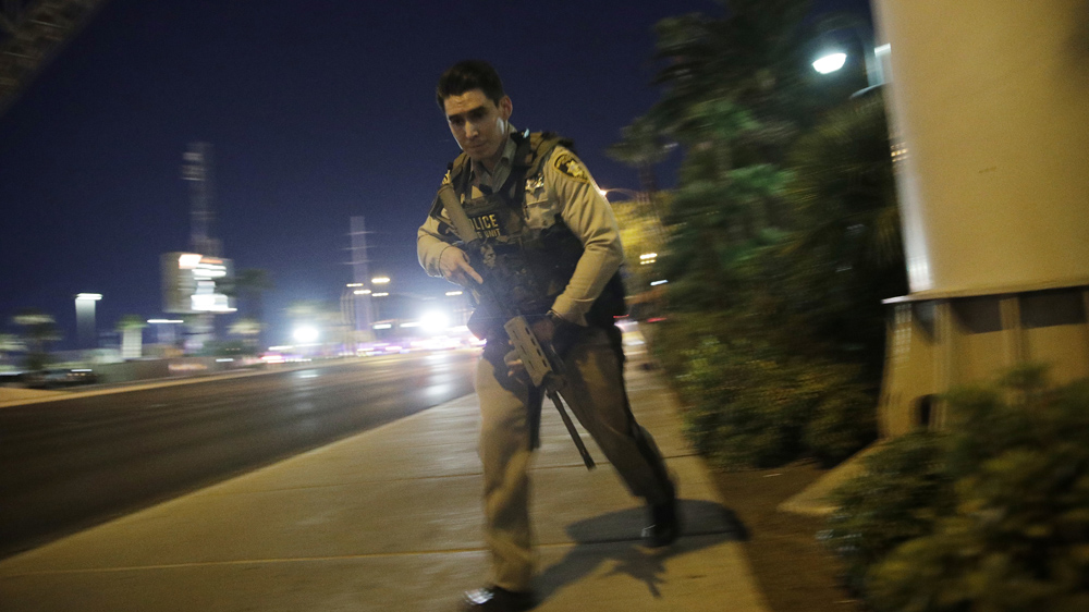 A police officer runs along a pavement near the shooting near the Mandalay Bay hotel and casino [John Locher/AP]