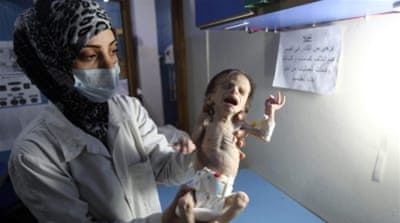 
A Syrian infant suffering from severe malnutrition is carried by a nurse at a clinic in the rebel-controlled town of Hamouria, Eastern Ghouta [File: Amer Almohibany/AFP/Getty Images]
