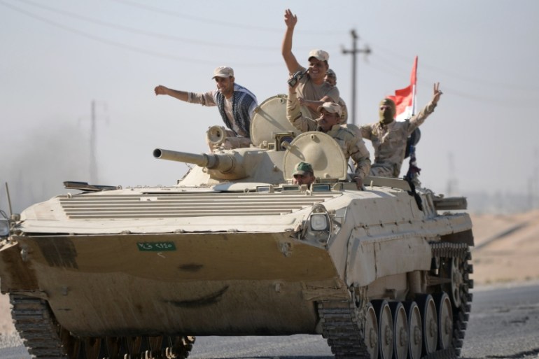 Iraqi army members advance in military vehicles in Kirkuk