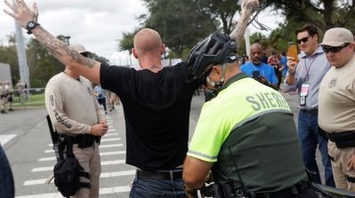 Police check a white supremacist for weapons before allowing him to pass at the University of Florida in Gainesville [Shannon Stapleton/Reuters] 