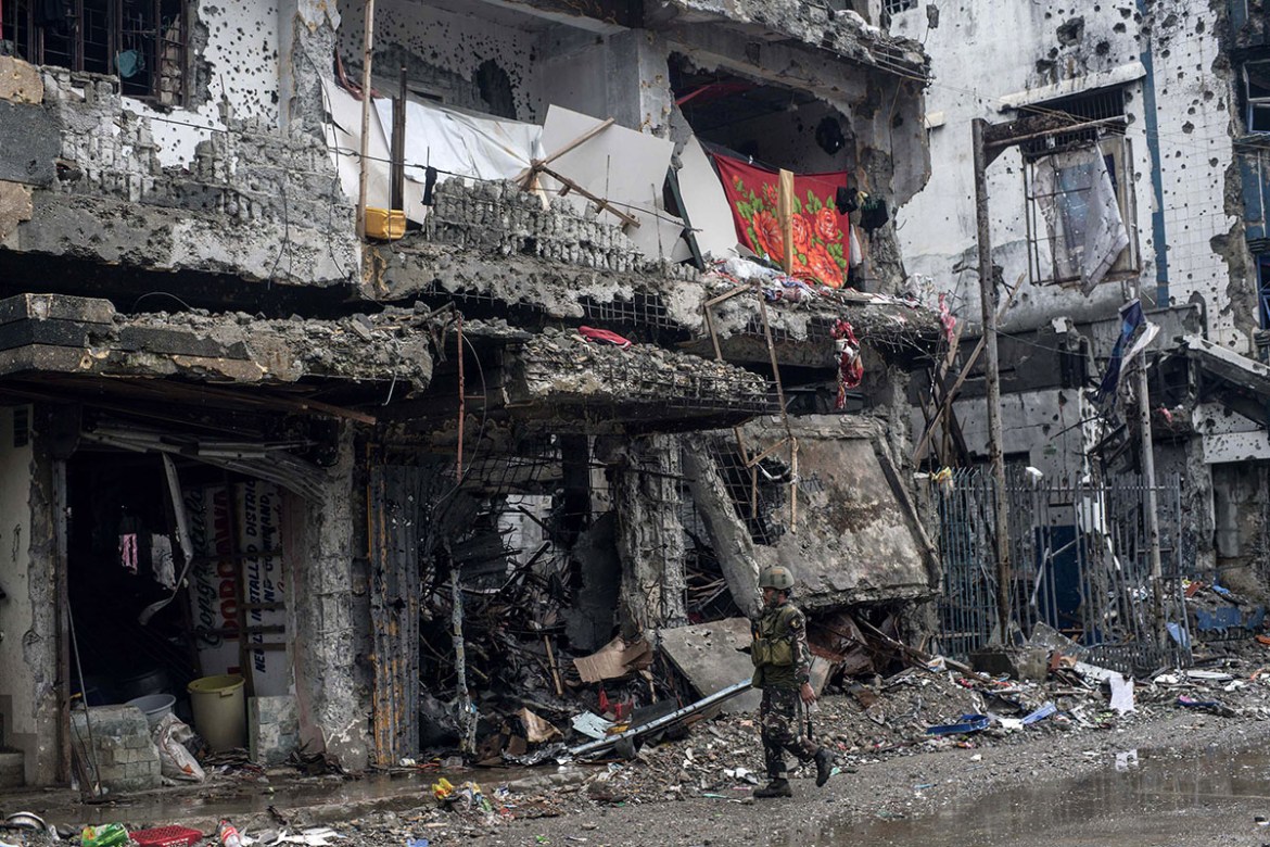 epa06271132 A Filipino soldier walks past bombed-out buildings in the ruined city of Marawi, southern Philippines, 17 October 2017. The President of the Philippines declared the city of Marawi liberat