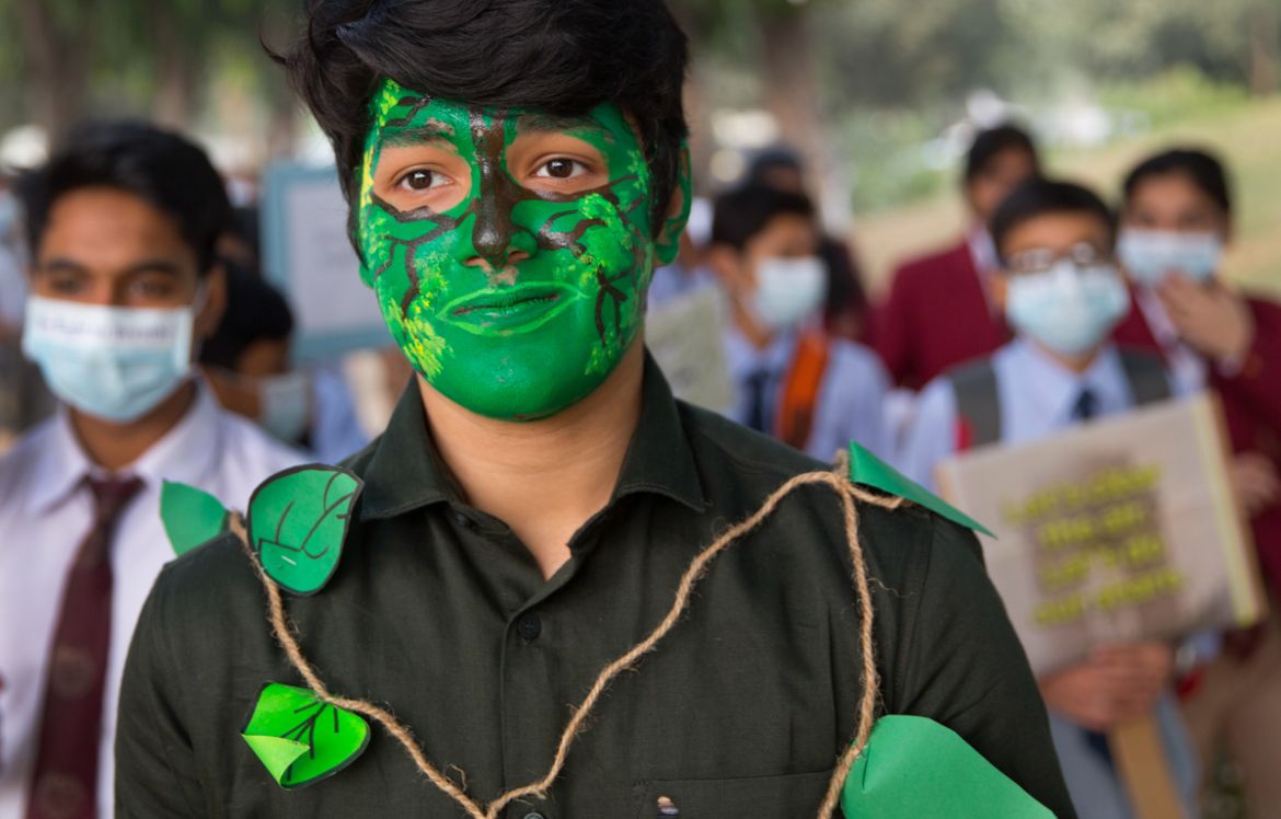 A School boy painted his face as a green tree participates in a march with other school children to express their distress on the alarming levels of pollution in the city, in New Delhi, India, Wednesd
