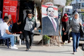 People walk next to a poster depicting Lebanon''s Prime Minister Saad al-Hariri, who has resigned from his post, along a street in the mainly Sunni Beirut neighbourhood of Tariq al-Jadideh in Beirut