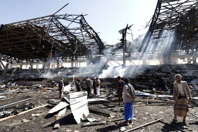 Yemeni men inspect the site of an air strike in the capital Sanaa