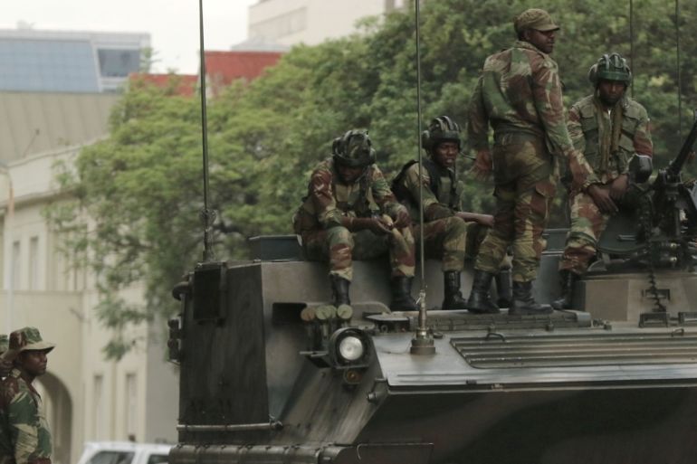 Soldiers are seen next to and on the armoured vehicle on the street in central Harare