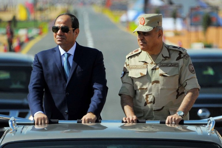 Egyptian President Abdel Fattah al-Sisi rides a vehicle with Egypt''s Minister of Defense Sedki Sobhi during a presentation of combat efficiency and equipment of the armed forces in Suez