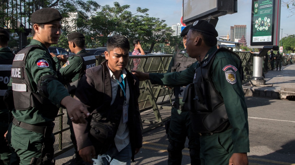 Policemen allow journalists to enter the barricaded area set up near the Supreme Court during the case hearing for the dissolution of the CNRP opposition party [Omar Havana/Al Jazeera]