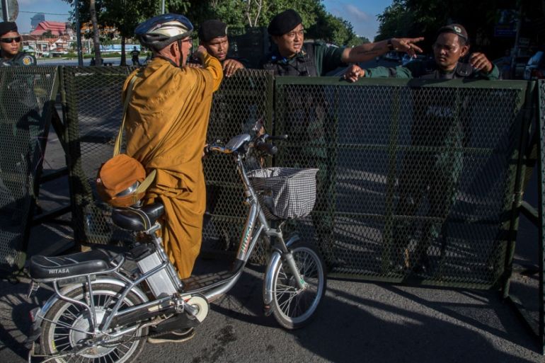 PHNOM PENH, CAMBODIA ñ NOVEMBER 16: A foreign Buddhist monk is stopped by police forces at one of the barricades set up on one of the main avenues with access to the Supreme Court during the hearing o