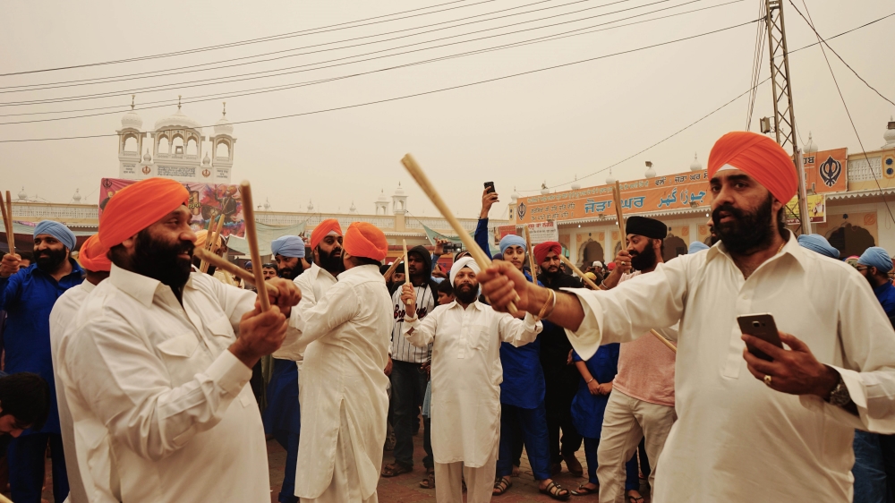 Sikhs perform a traditional Punjabi dance 'Dandiya' during Guru Nanak's birth celebrations in Nankana Sahib [Sabrina Toppa/Al Jazeera]