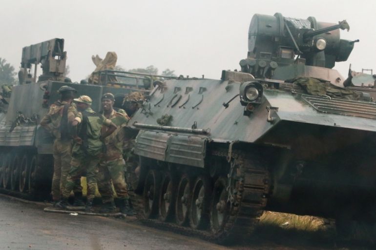 Soldiers stand beside military vehicles just outside Harare, Zimbabwe