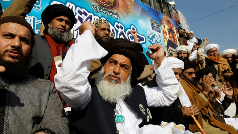 Khadim Hussain Rizvi, leader of Tehrik-e-Labaik Pakistan islamist political party, raises his arms as supporters chant slogans at their protest site at Faizabad junction in Islamabad