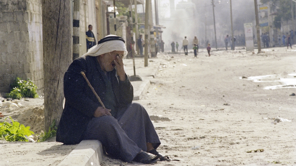 An old man tries to clear his eyes and catch his breath after he was hit by a cloud of tear gas in Khan Yunis, in the occupied Gaza Strip, during a demonstration, January 10, 1987 [AP/Dieter Endlicher]