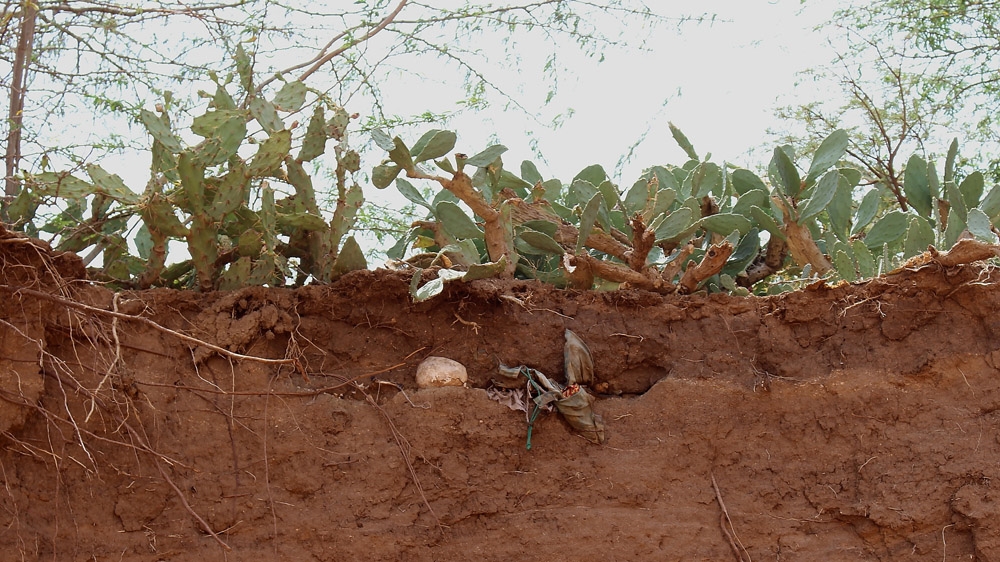 The skeleton of a rebel lies in a shallow grave at Malko Durduro, exposed after a night of heavy rain [Matthew Vickery/Al Jazeera]