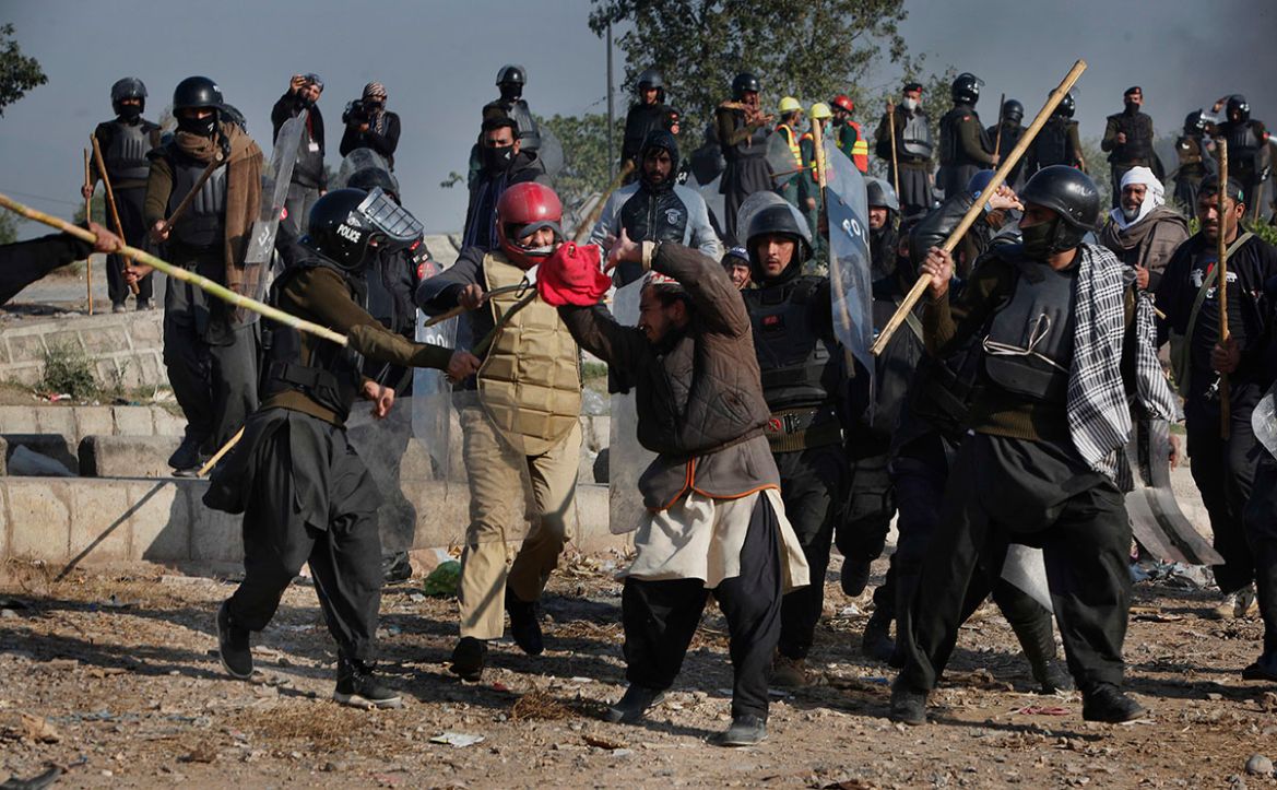 Pakistani police officers beat a protester during a clash in Islamabad, Pakistan, Saturday, Nov. 25, 2017. Pakistani police have launched an operation to clear an intersection linking capital Islamaba