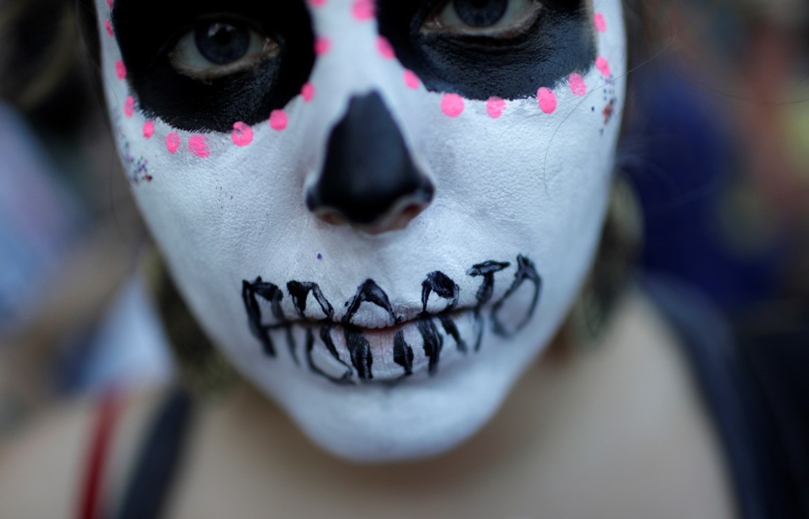 A woman demonstrates against Brazil''s congressional move to criminalize all cases of abortion, including cases of rape and where the mother''s life is in danger, with a face painting representing a wom