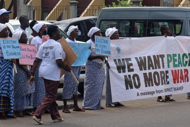Women hold banners encouraging peace during a peace mediation meeting held by ECOWAS for Liberia''s presidential run-off election, in the Sinkor neighbourhood of Monrovia