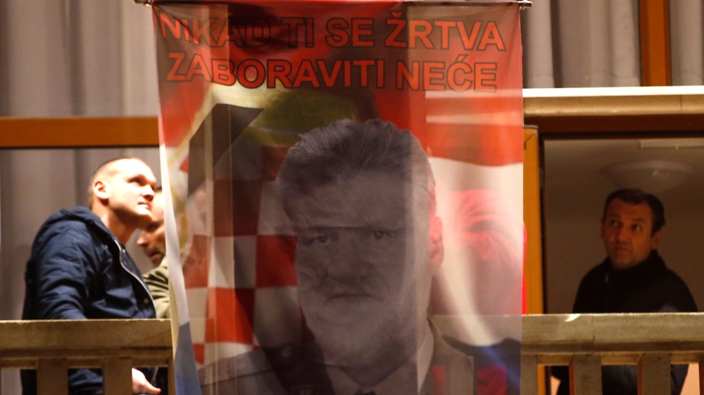 Bosnian Croats hang a flag displaying a portrait of Praljak and a message [Dado Ruvic/Reuters]