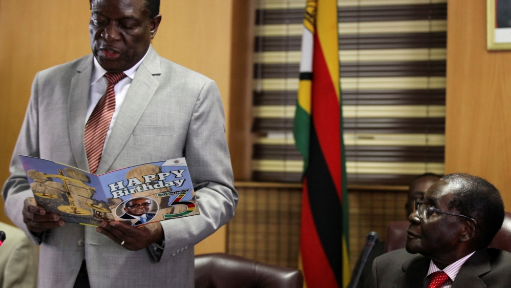 Mugabe looks on as Mnangagwa reads a card during Mugabe's 93rd birthday celebrations in Harare, Zimbabwe, February 21 [Philimon Bulawayo/Reuters]