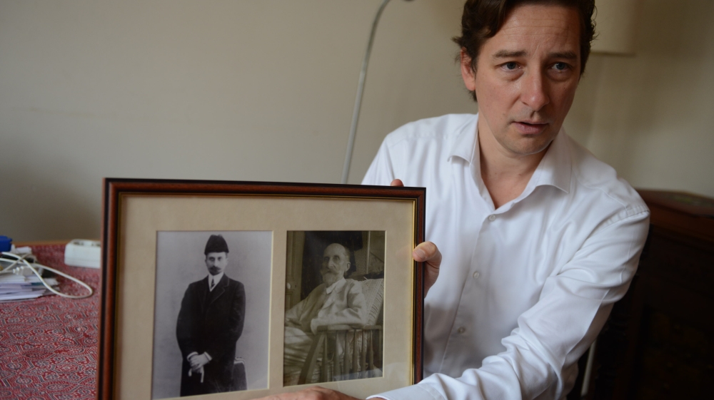 David Henderson-Stewart shows photos of his great-great-grandfather Nikolay Lvov who died in exile in France in 1940 [Sergey Kozmin/Al Jazeera] 
