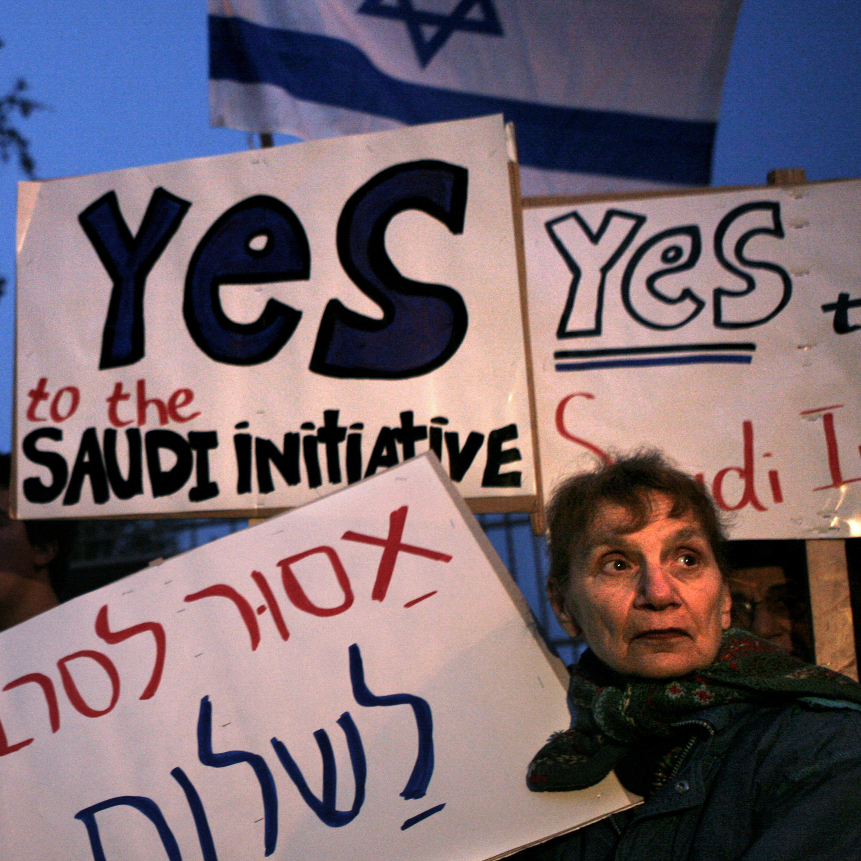 An Israeli activist holds a placard reading, 