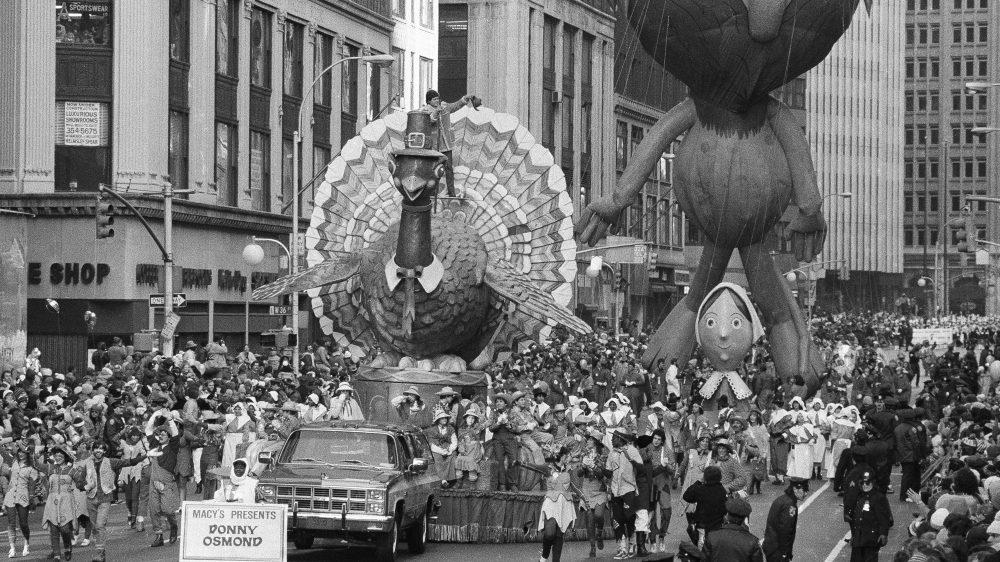 A turkey float and a pilgrim woman float move down Broadway in New York City during the Macy's Thanksgiving Parade on November 26, 1981 [AP]