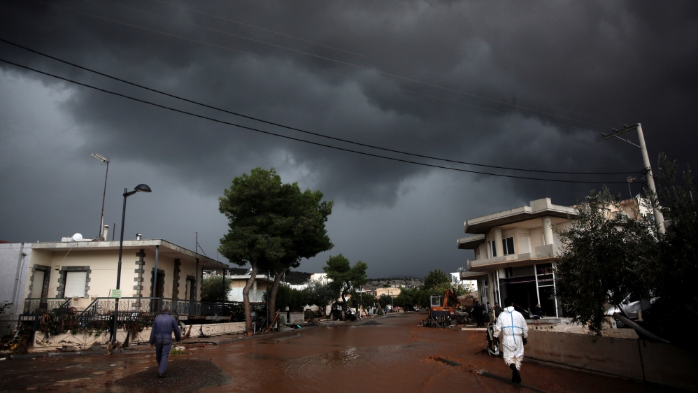 Storm clouds are seen over a flooded street in Mandra Mandra [Alkis Konstantinidis/Reuters]