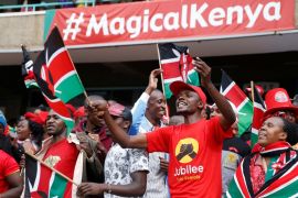 People cheer as they wait for the inauguration ceremony to swear in KenyaÕs President Uhuru Kenyatta at Kasarani Stadium in Nairobi