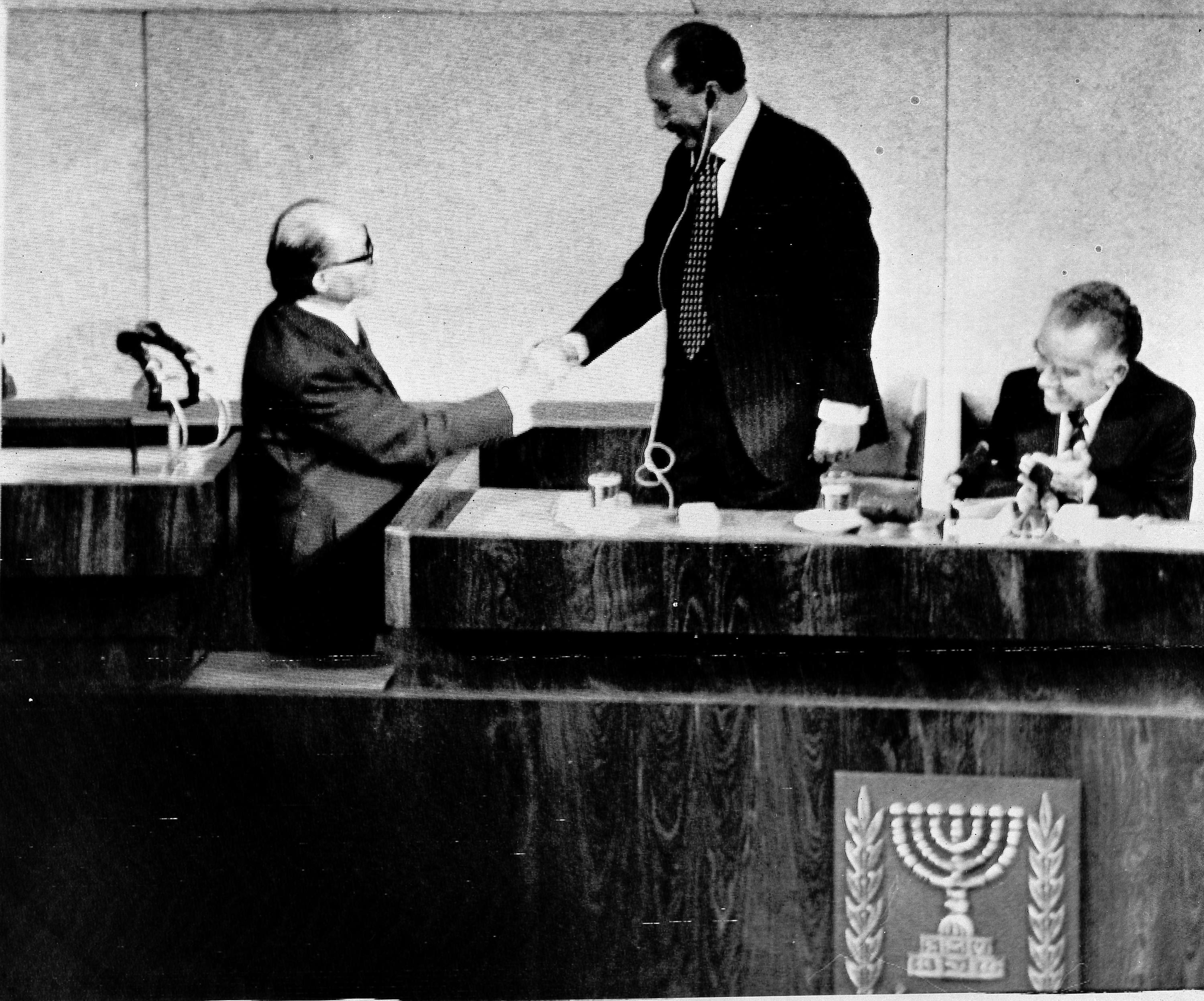 Egyptian President Anwar Sadat shakes hands with Israeli Prime Minister Menachem Begin in the Knesset on November 20, 1977 [Shmuel Rachmani/AP]