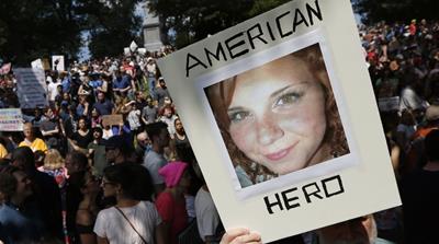 A counterprotester holds a photo of Heather Heyer at a Free Speech rally in Boston [File: Michael Dwyer/AP Photo]