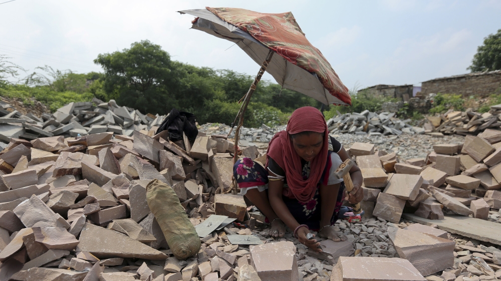 A young woman carves cobblestones in Budhpura [Ashish V/Al Jazeera]